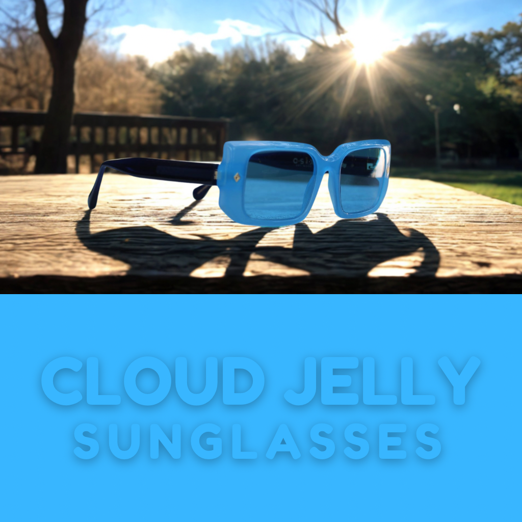 “Cloud Jelly River sunglasses resting on textured stone near water, featuring vibrant blue frame and urban background”