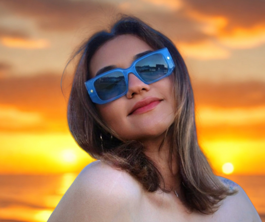 “Model wearing Cloud Jelly River sunglasses with bold blue jelly frame, smiling under clear blue sky”